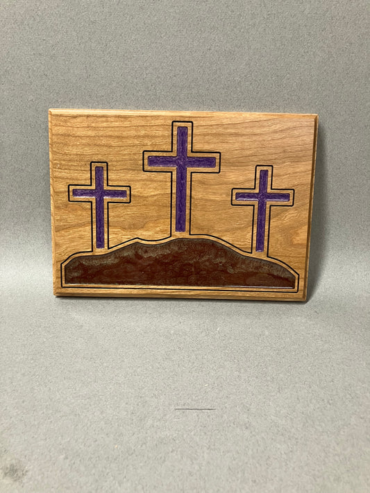 The three crosses on a hill in purple.