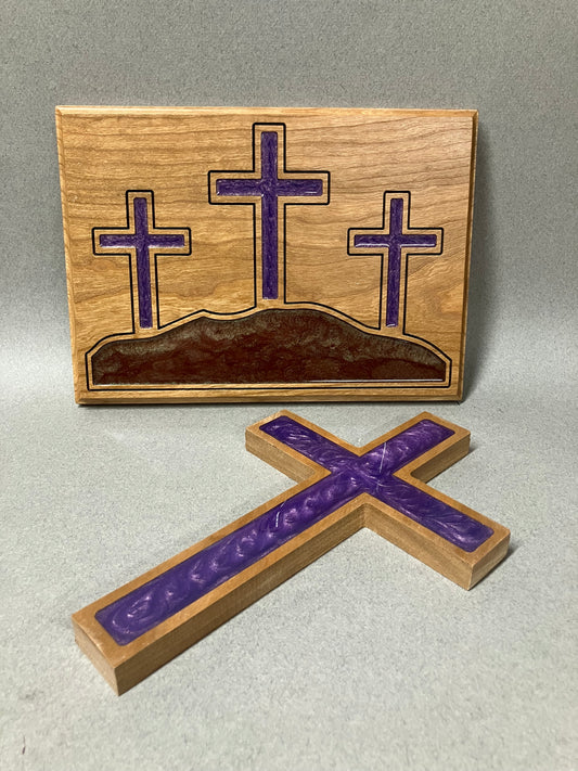 Three crosses on a hill and a purple cross.